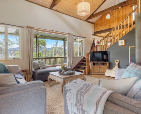 Lounge Detail: A close-up of the seating area featuring a large window that overlooks the water, with a comfortable sofas, smart TV and Bluetooth speaker.