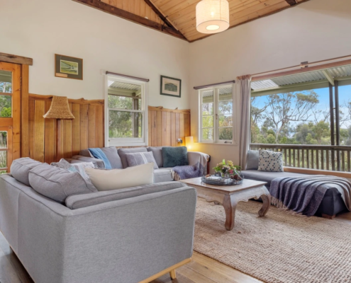 Living Room Corner details: A secondary angle of the main lounge showing the transition between the gray sofa and the timber-clad walls.
