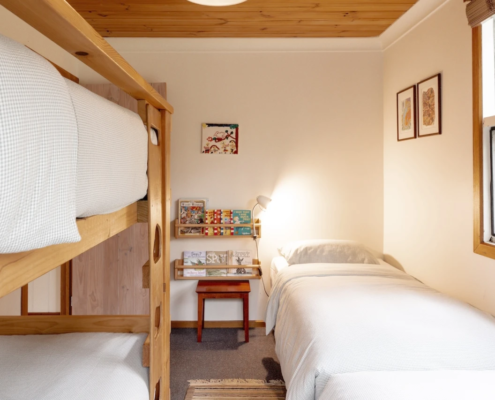 Bunk Room (Bedroom 3): A bright view of the bunk room featuring two single beds and a timber bunk bed set, sleeps 4